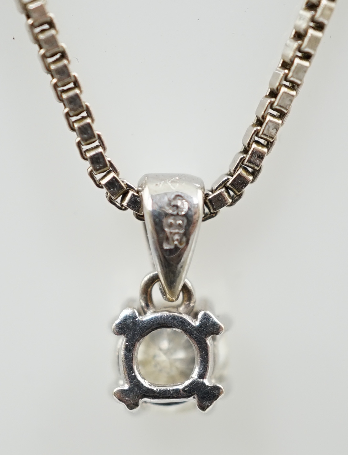 A modern 14k white gold and solitaire diamond set pendant, on a 14k white gold chain